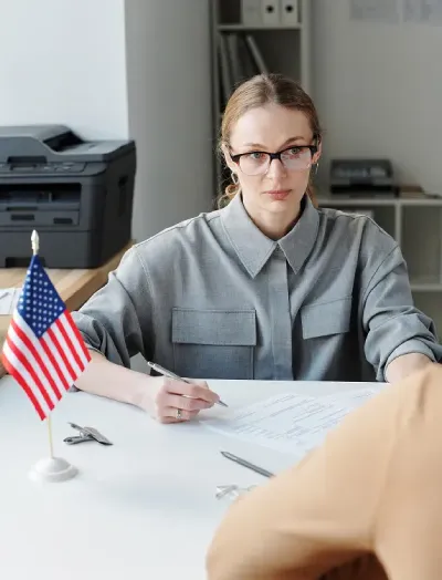 vertical-shot-serious-woman-working-us-embassy-consulate-interviewing-unrecognizable-person (1)
